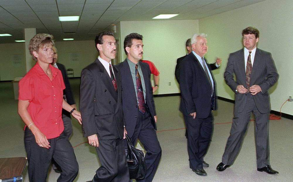LAPD Officers Ted Briseno (second from left) and Laurence Powell (right) are escorted by a Ventura County deputy sheriff and Powell's father (second from right) through the media room after they were acquitted of all charges except for one against Laurence Powell on April 29, 1992. A mostly white jury acquitted the four police officers accused of beating Rodney King.
