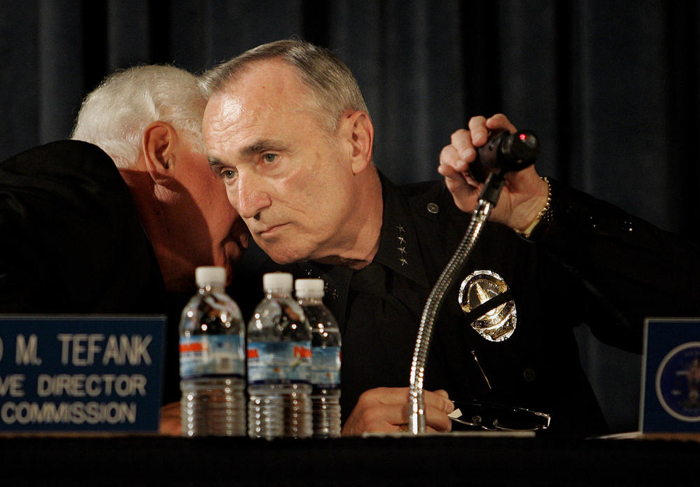 Los Angeles Police Commission Executive Director Richard Tefank (left) speaks to Los Angeles Police Commissioner Bill Bratton during a Police Commission meeting on May 8, 2007. The agenda included a discussion of the LAPD's response to the May Day demonstration held at MacArthur Park.