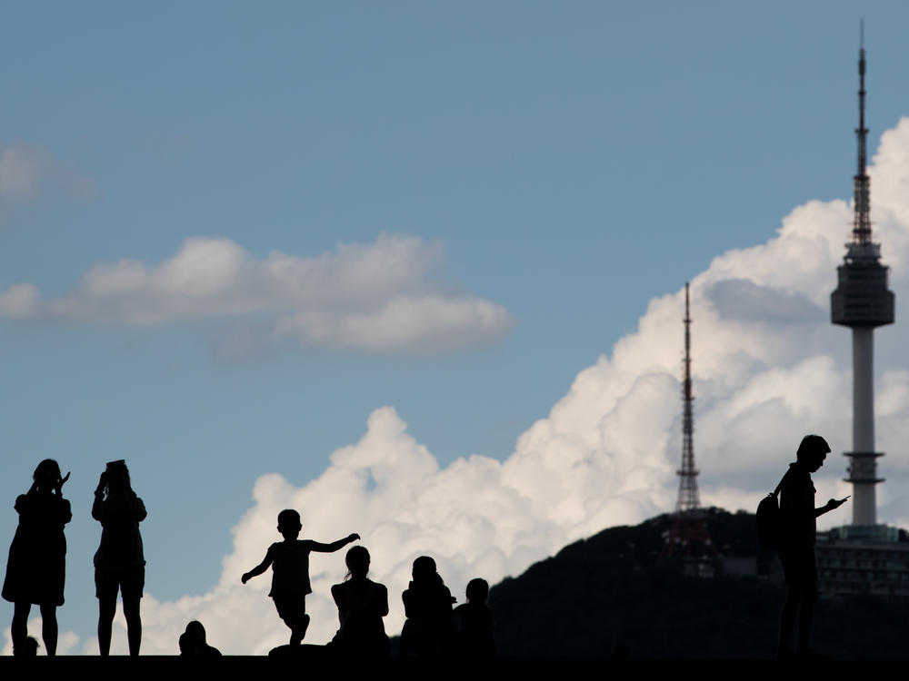 The silhouettes of people are seen as they stand outside the War Memorial of Korea museum in Seoul, South Korea, on Friday, Aug. 11, 2017.