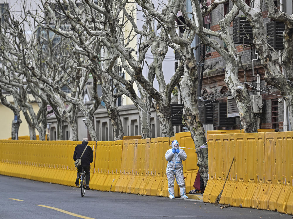 A worker in protective gear stands by barriers set up as part of lockdown measures against COVID-19 in Jing'an district, in Shanghai on March 31.