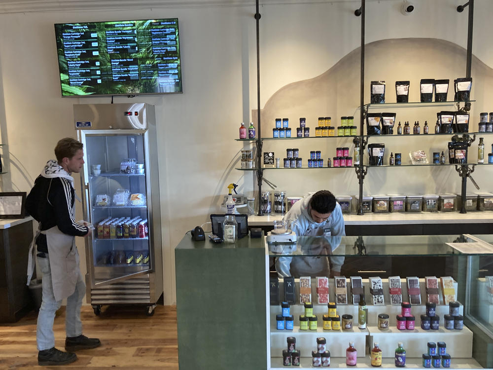 Marijuana dispensary manager LeRoy Roybal, right, and bud tender Benjamin Oliver prepare on Tuesday, March 29, 2022, for the opening of New Mexico's regulated market for recreational cannabis at a Minerva Canna store in Santa Fe, N.M.