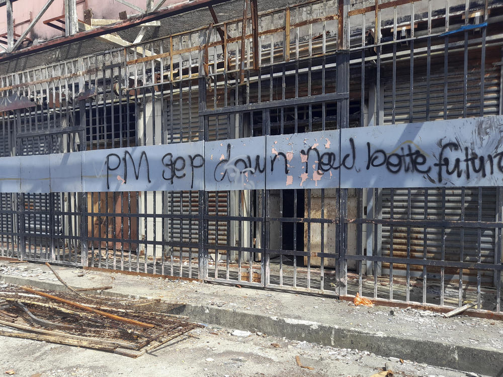 Graffiti written on the burnt out buildings from riots in Honiara's Chinatown from Nov. 2021, is seen in the Solomon Islands on March 30, 2022.