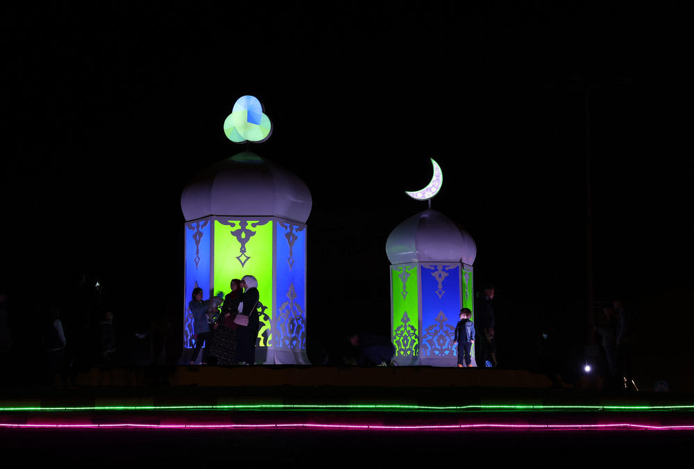 <strong>Gaza City, Gaza:</strong> This long exposure picture shows Palestinians standing next to the lantern known in Arabic as 