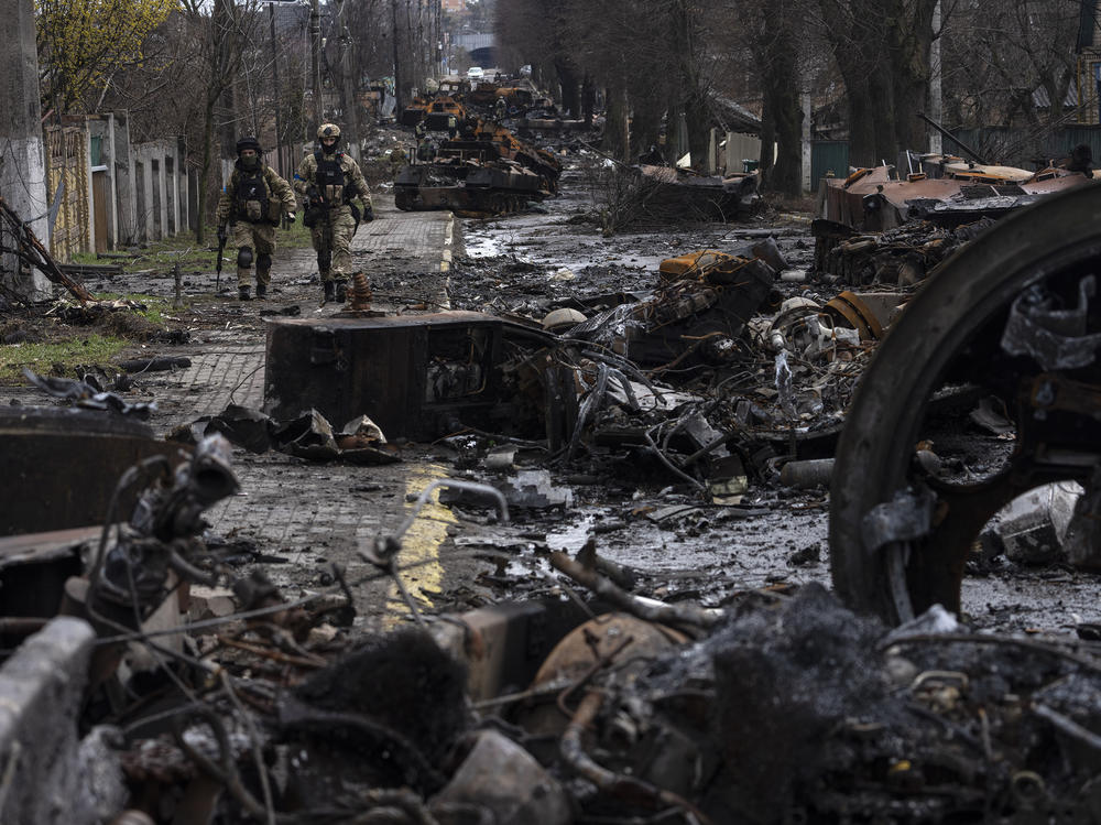 Soldiers walk amid destroyed Russian tanks in Bucha, in the outskirts of Kyiv, Ukraine, on Sunday.