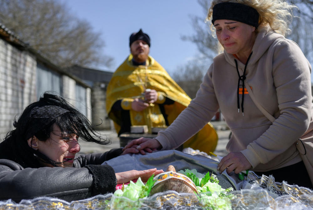 <strong>April 2:</strong> A woman, left, mourns her husband, a soldier who died during fights with Russian troops, at a funeral in Mykolaiv.