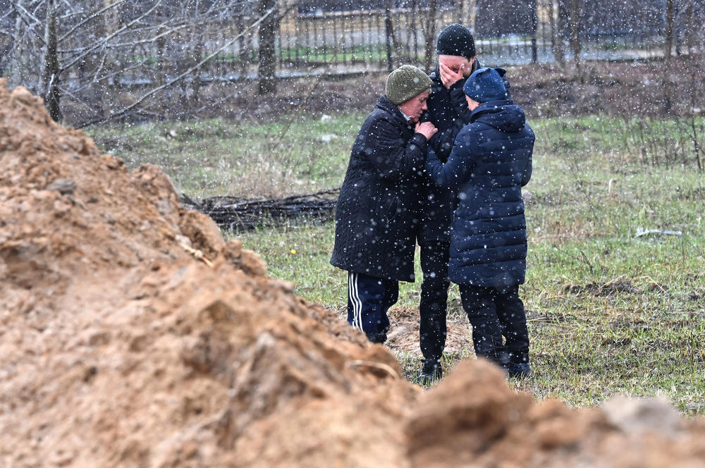 <strong>April 3:</strong> People react as they gather close to a mass grave in the town of Bucha, just northwest of Kyiv.