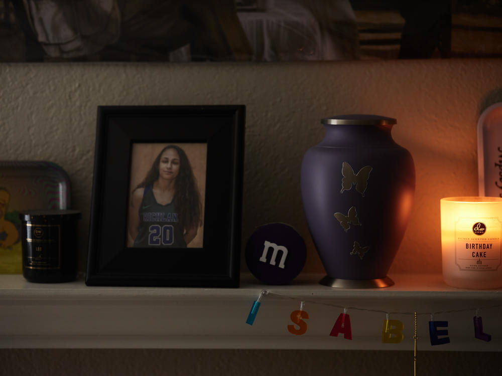 Family photos of Allyssa Lewis'  family and her sisters ashes in her living room in Richardson, Texas, on April 4, 2022.