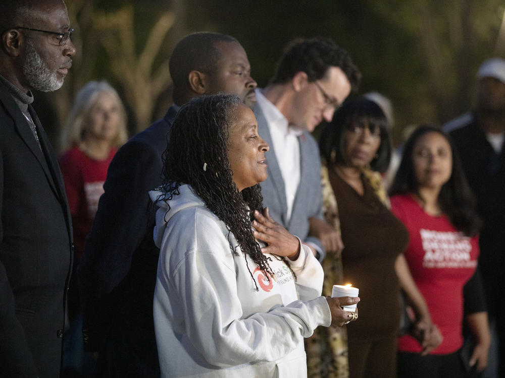 People attend a candlelight vigil to mourn for the death of mass shooting victims at a park on Sunday in Sacramento, Calif.