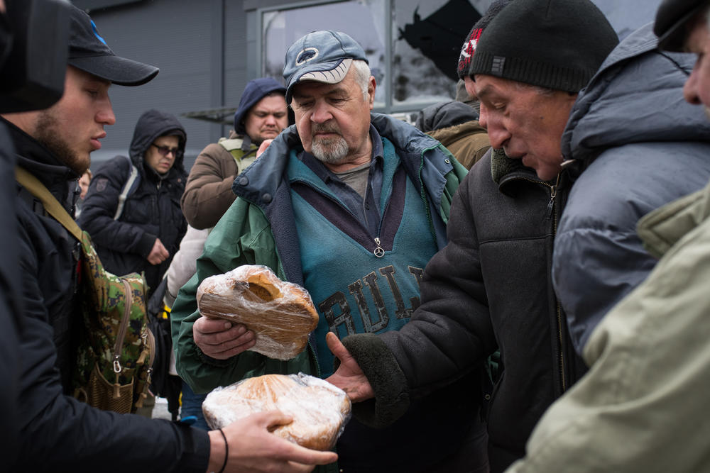 Ukrainian troops distribute food aid to Bucha residents on Tuesday.