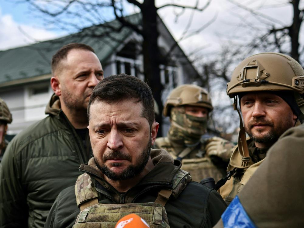Ukainian President Volodymyr Zelenskyy, center, speaks to the press in the town of Bucha on the northwest edge of the Ukrainian capital Kyiv on Monday.