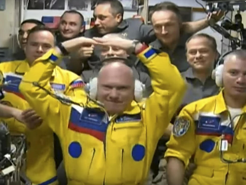 In this photo taken from video footage released by the Roscosmos Space Agency, three Russian cosmonauts sport yellow spacesuits upon arriving on the International Space Station. A NASA astronaut now says it was not in support for Ukraine, but for the Russians' university school colors.