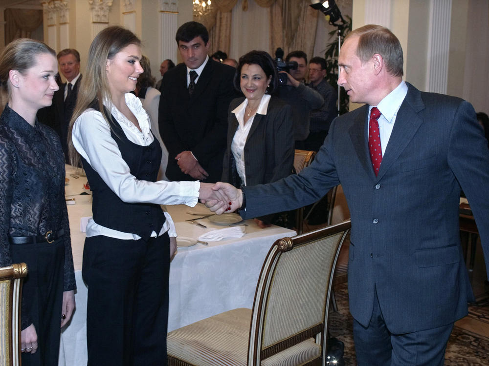 Russian President Vladimir Putin shakes hands with rhythmic gymnast Alina Kabaeva in 2004.