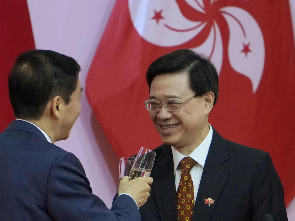 Hong Kong's Chief Secretary John Lee, right, attends a reception, following the flag-raising ceremony for the celebration of China's National Day, in Hong Kong on Oct. 1, 2021.