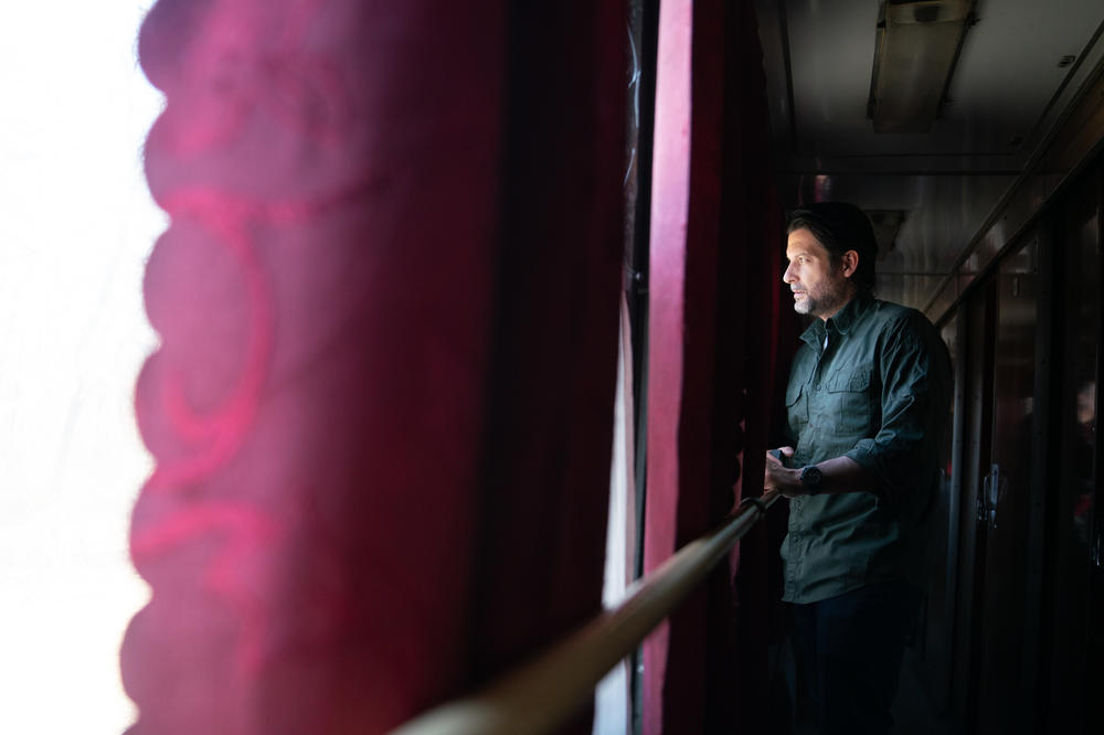 Brett Velicovich, who works with Stern, looks out the train window while he awaits their arrival in Kyiv.