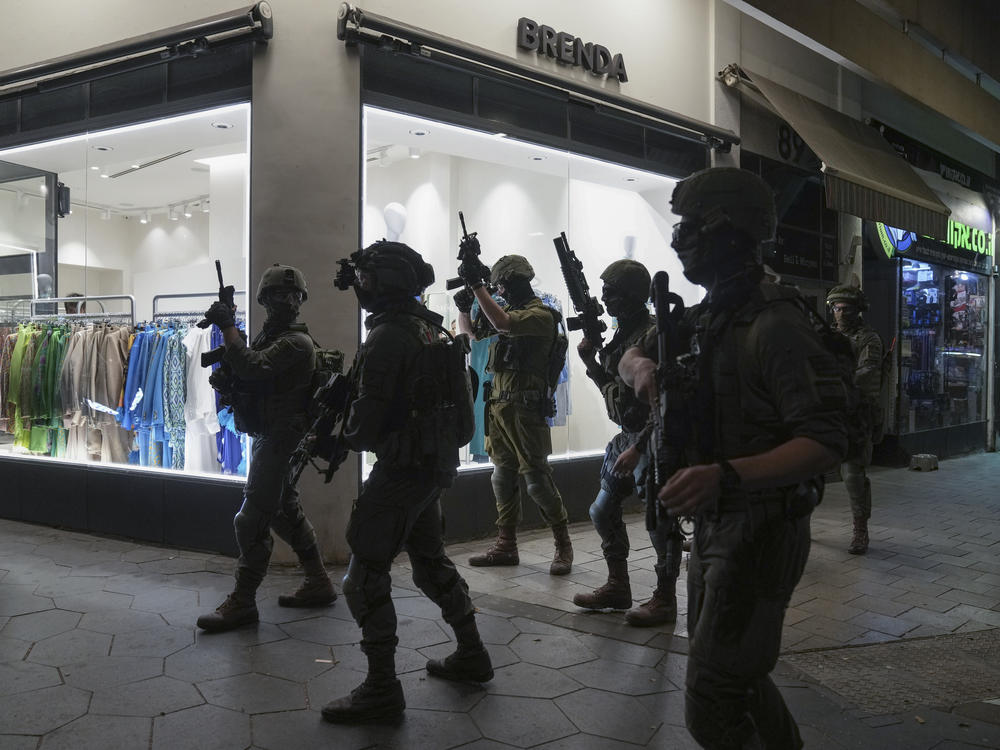 Israeli security forces search for assailants near the scene of a shooting attack in Tel Aviv, on Thursday.