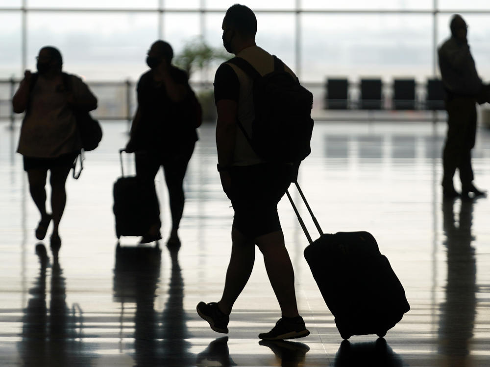 Travelers move through Salt Lake City International Airport on Aug. 17, 2021. The Federal Aviation Administration said Friday that it's seeking record civil fines against two passengers who assaulted other people on flights last summer.