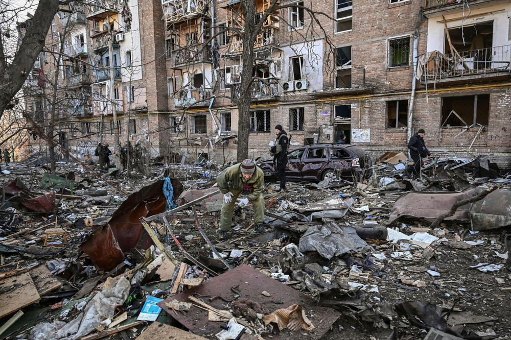 Ukrainian service members stand beside a building in a residential area of Kyiv that was damaged by shelling in March as Russian troops tried to encircle the Ukrainian capital as part of their slow-moving offensive.