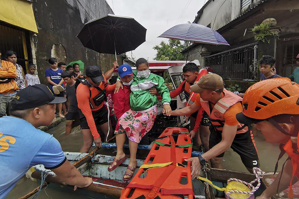 Rescuers evacuate a resident to safer ground at Abuyog, Leyte province, in the central Philippines on Sunday.