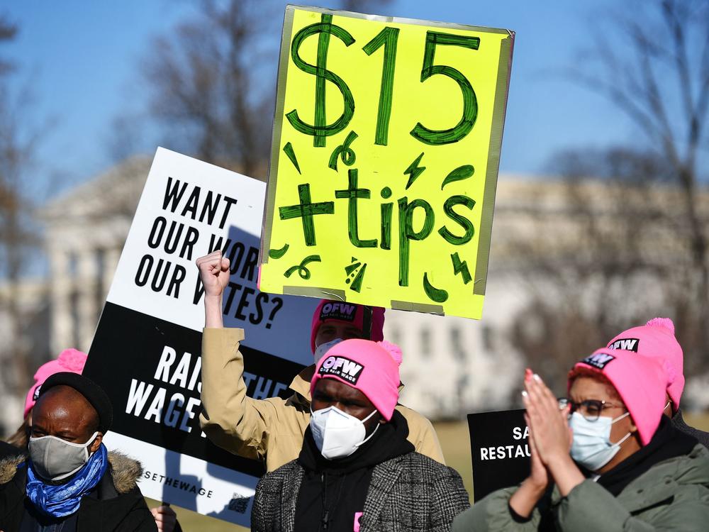 An activist holds a placard demanding a $15-per-hour minimum wage and tips for restaurant workers during a rally at the U.S. Capitol earlier this year.