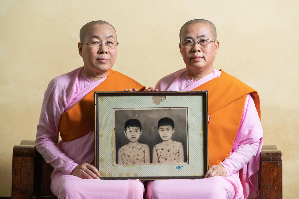 Twin sisters at a Buddhist monastery near the Hpa-an Township in Myanmar share a photo of themselves as children.
