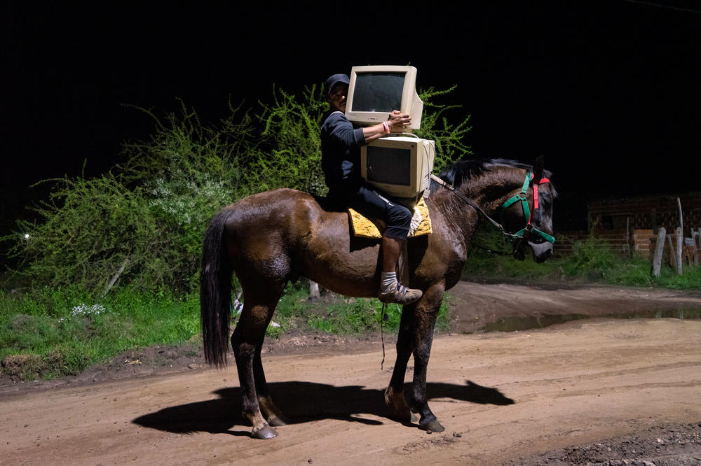 A man transports computer monitors on horseback in Corrientes, Argentina.