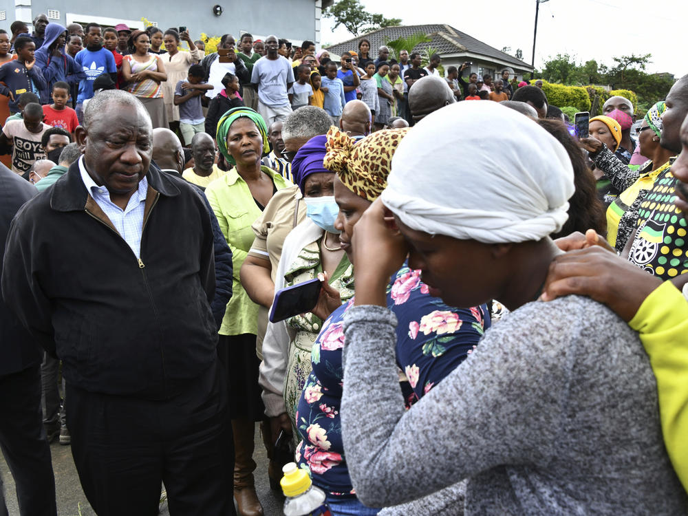 South African President Cyril Ramaphosa, left, speaks to various grieving family members, as part his visit and assessing the damage following the heavy rainfall which resulted in roads collapsing, properties damaged and lives lost outside of Durban.