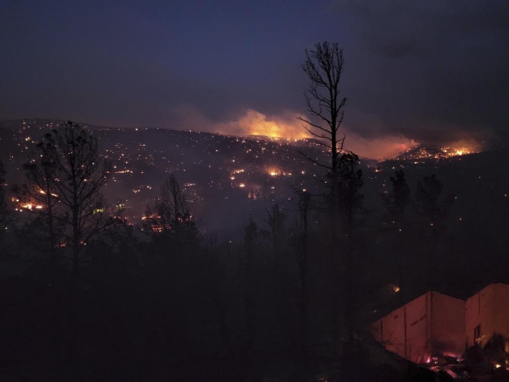 A fire burns along a hillside in Ruidoso, N.M., on Wednesday. Officials say a wildfire has burned about 150 structures, including homes, in Ruidoso.