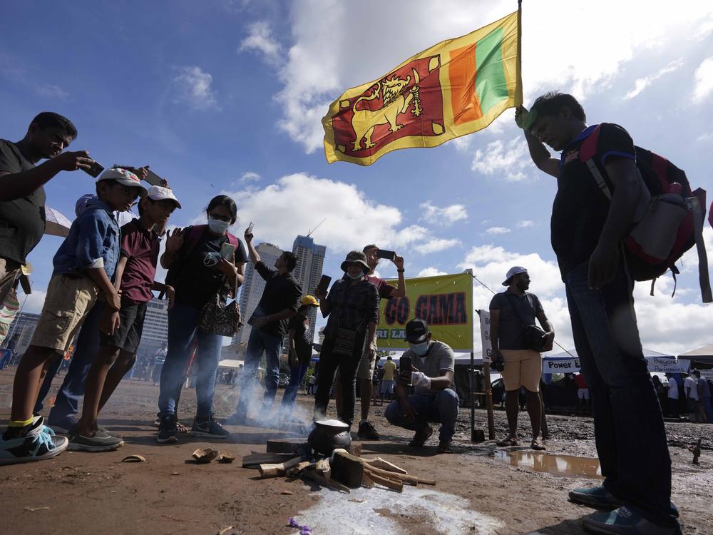 Sri Lankans boil a pot of milk as customary to welcome the dawn of Sinhalese and Tamil new year at a protest site near the president's office in Colombo, Sri Lanka, Thursday, April 14, 2022.