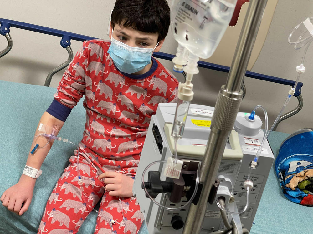 A case of COVID-19 brought 12-year-old Harry Nelson to the emergency room in Syracuse, N.Y., where cases are surging, His mother, photographer Paula Nelson, says he first had mild symptoms — just a headache — but later ran a high fever and began vomiting, which meant he couldn't keep down fever-relief meds. At the ER, he needed saline to rehydrate, Tylenol for his fever and meds to stop vomiting.