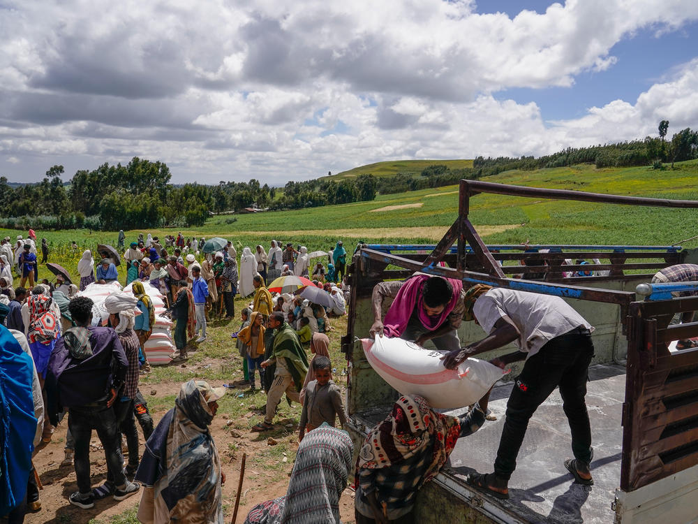 Volunteers unload food aid in Chena, Ethiopia, one of many parts of the world where conflict has fueled hunger.