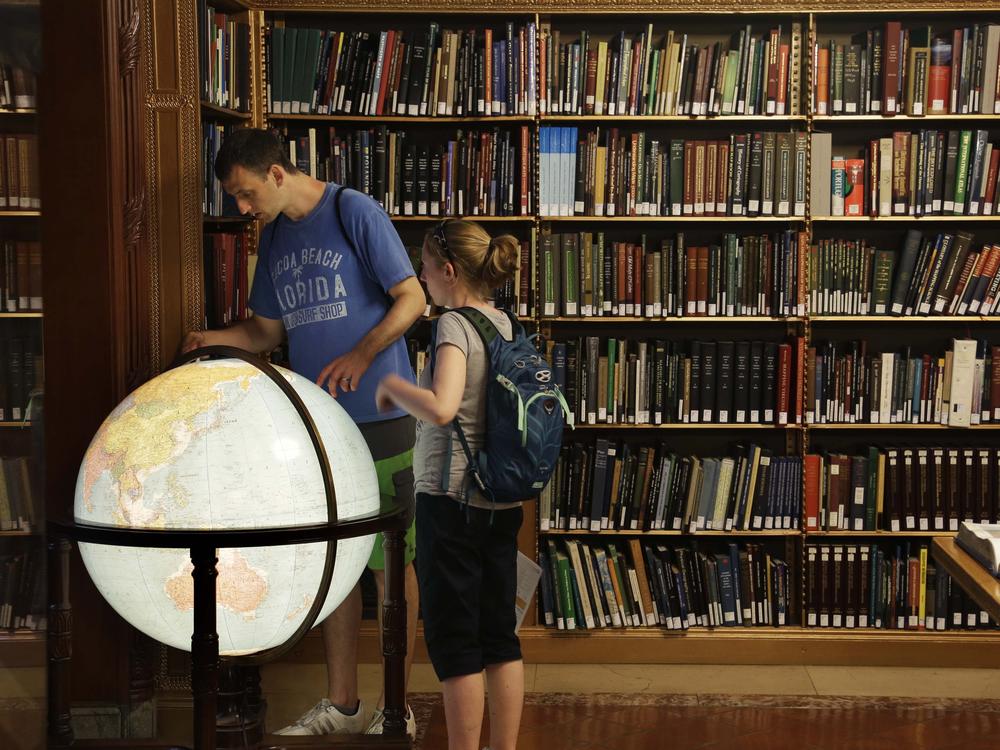 Visitors look at a globe in the map division at the main branch of the New York Public Library in New York. The library announced an effort this week to make commonly banned books available through their app.