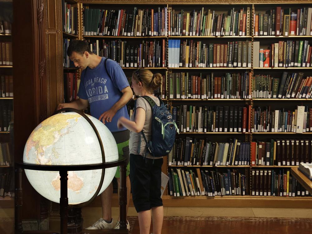 Visitors look at a globe in the map division at the main branch of the New York Public Library in New York. The library announced an effort this week to make commonly banned books available through their app.