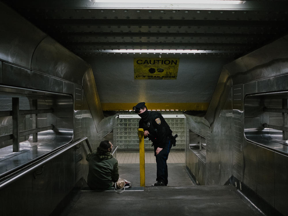 Officer Alexander Bires of SEPTA, the transit system for the Philadelphia region, speaks with a homeless man about outreach services at the 11th Street stop on the Market-Frankford Line in Philadelphia.