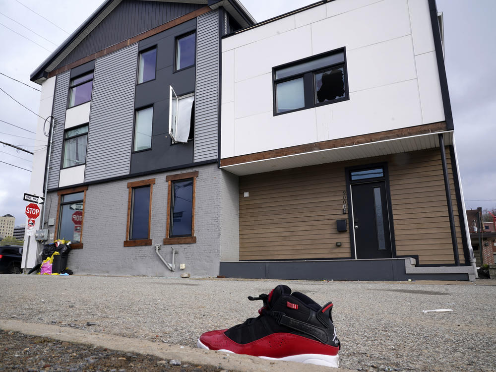 A lone sneaker lies near a short-term rental property where police say a shooting took place in Pittsburgh early Sunday morning, April 17, 2022.