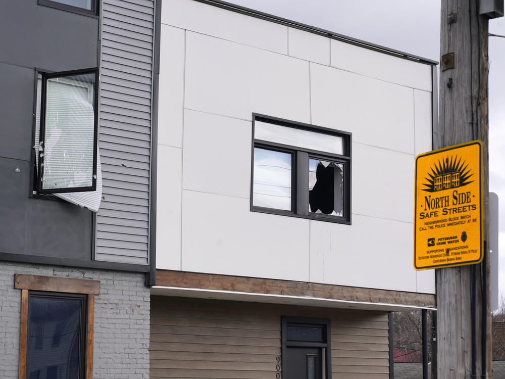 Windows are shot out on the second floor of the short-term rental property where police say a shooting took place at a house party in Pittsburgh early Sunday morning.