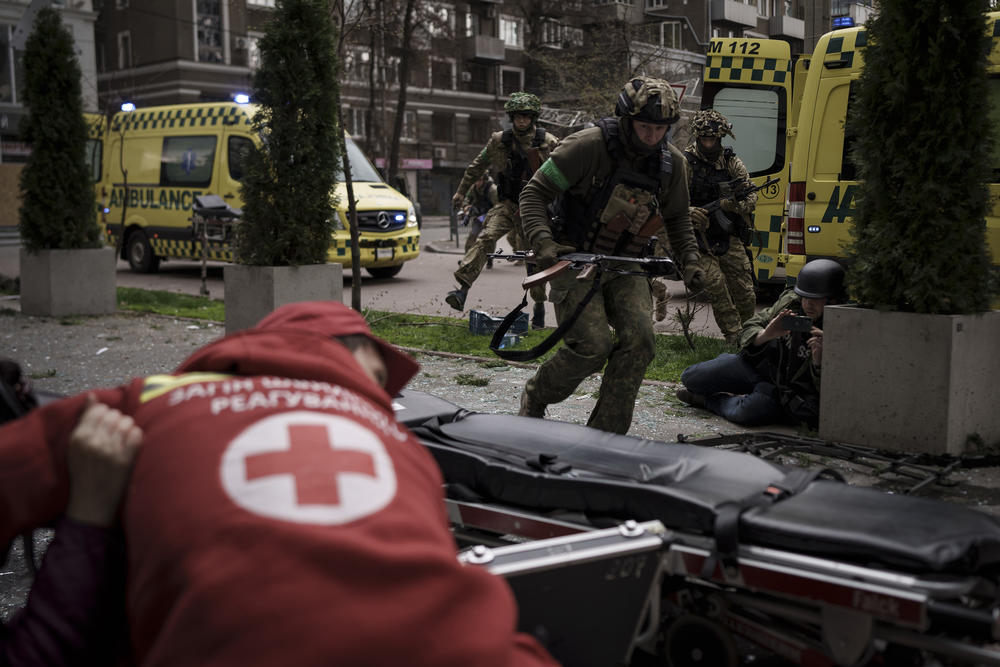 <strong>April 17:</strong> Ukrainian servicemen run for cover as explosions are heard during a Russian attack in downtown Kharkiv, Ukraine.