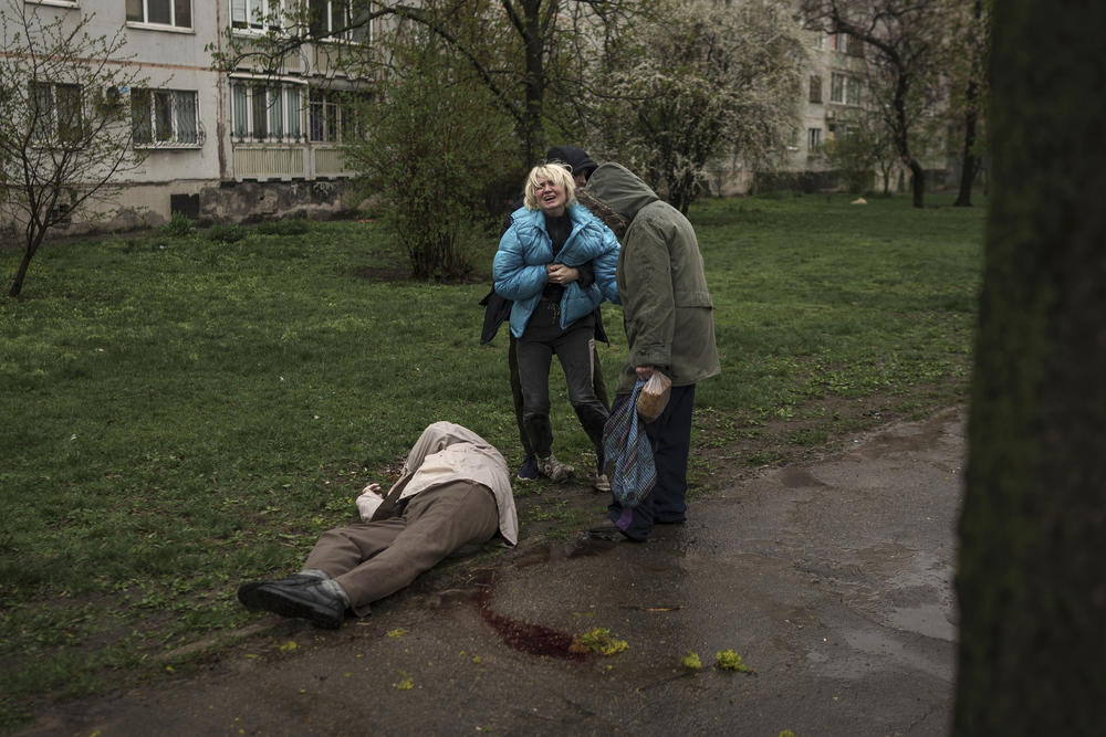 <strong>April 18:</strong> A woman cries next to the body of her father lying on the ground after a Russian attack in Kharkiv, Ukraine.