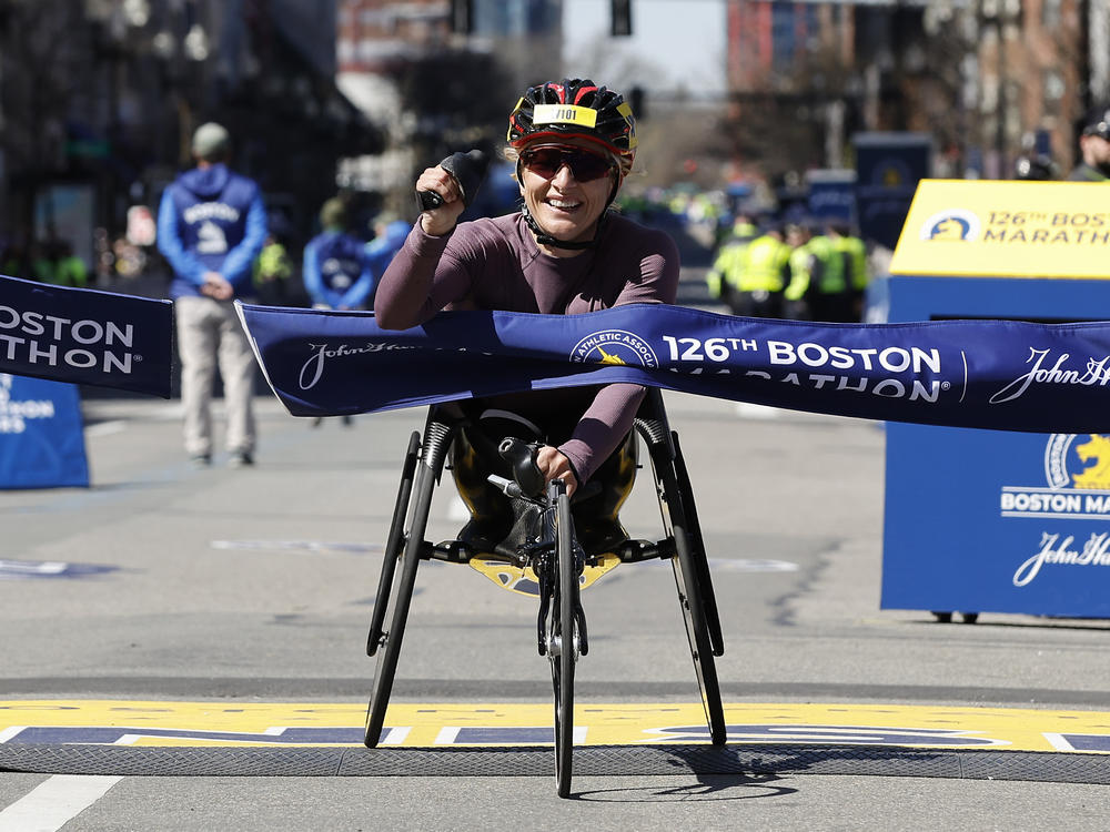 Manuela Schar, of Switzerland, hits the tape to win the women's wheelchair division of the 126th Boston Marathon on Monday.