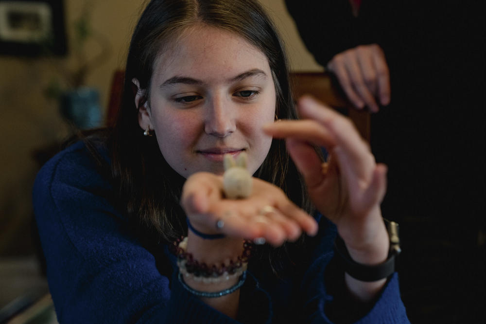 Erika, the older daughter in the Koliubaiev family, gently touches a stuffed bunny while making Easter eggs.