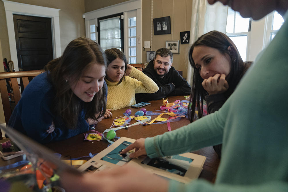 Hosts Susan Thompson-Gaines and David Gaines show the Koliubaiev family their wedding photos while making Easter eggs at their home.