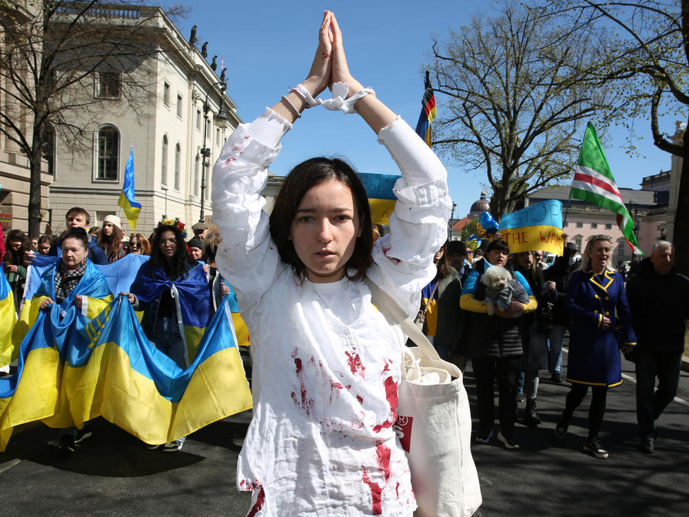 A woman representing a rape victim leads protesters in Berlin demonstrating in an April 16 march against Russian military aggression in the ongoing wars in Ukraine and Syria.