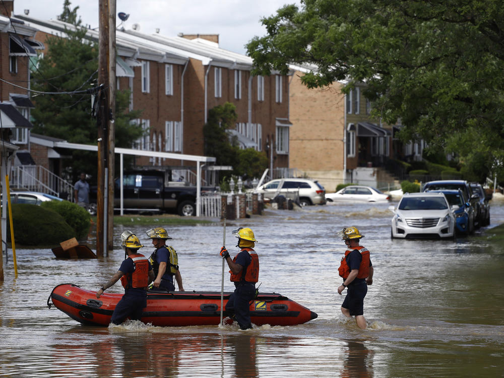Philadelphia firefighters walk through a flooded neighborhood on Aug. 4, 2020, after Tropical Storm Isaias moved through.