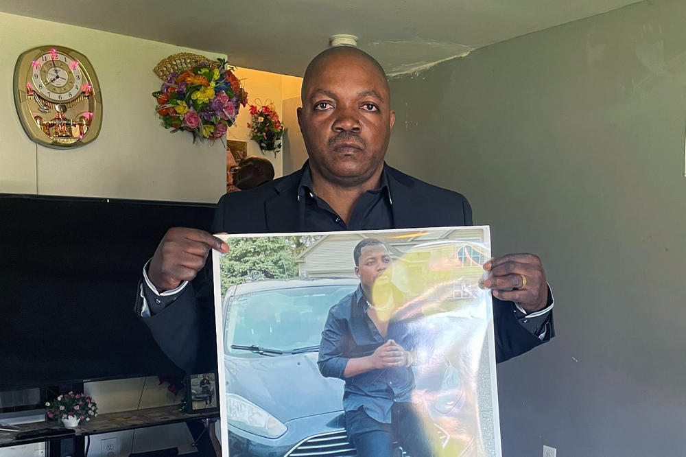 Peter Lyoya holds up a picture of his son Patrick Lyoya, 26, in his home in Lansing, Mich., on Thursday.