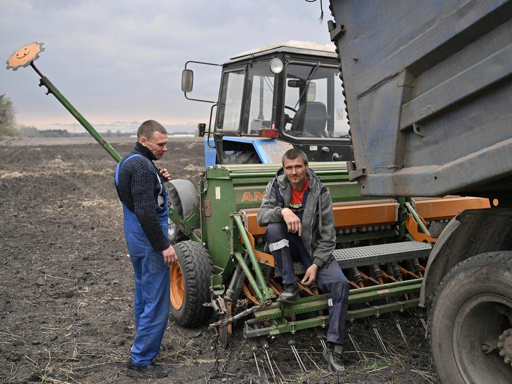 Two farmers take a break from sowing their field with oat, east of Kyiv on April 16.
