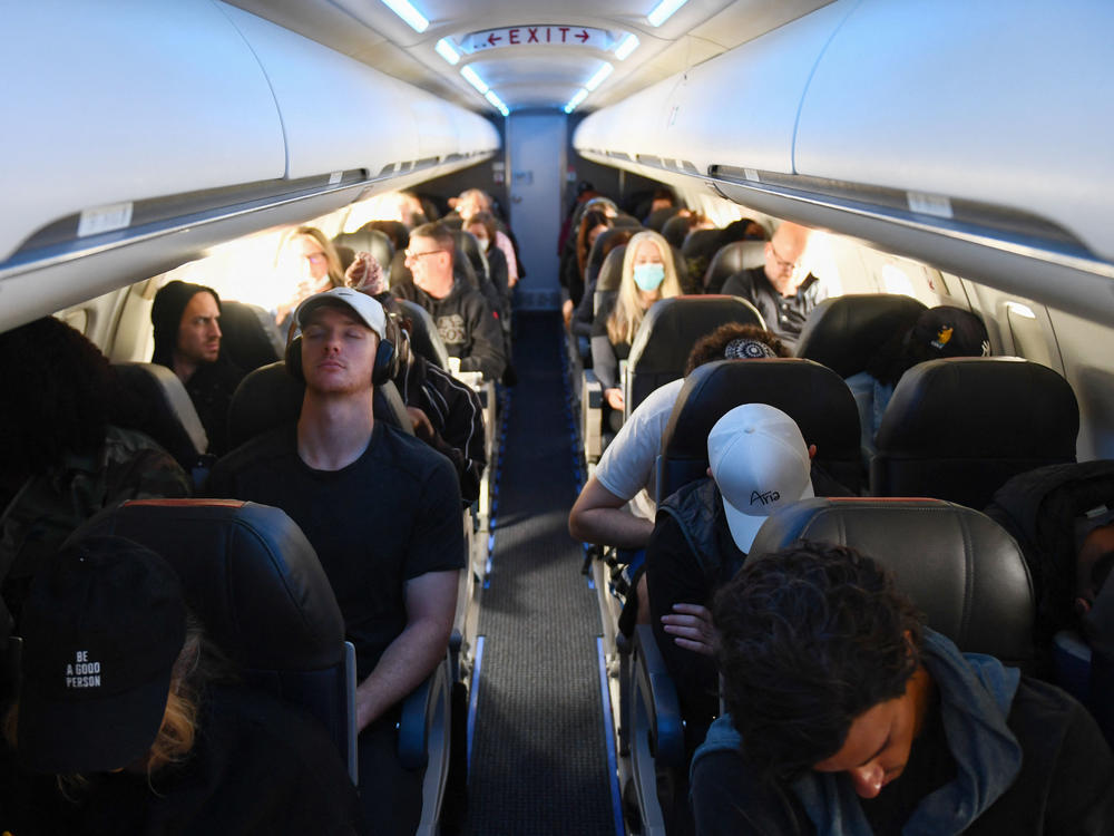 Airline passengers, some not wearing face masks following the end of the federal mask mandate, sit during a American Airlines flight operated by SkyWest Airlines from Los Angeles International Airport to Denver, on Tuesday.