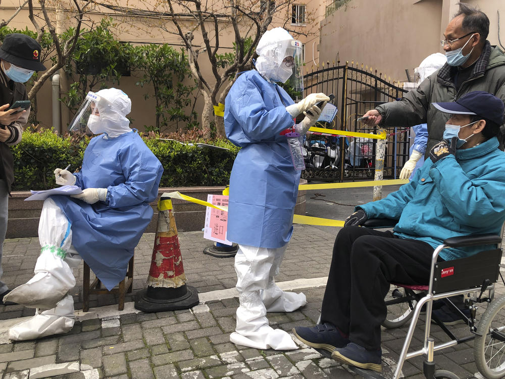 Workers in protective gear register residents for COVID-19 testing in the Jingan district of western Shanghai, China, on April 1, 2022. Shanghai allowed 4 million more people out of their homes Wednesday as coronavirus rules that shut down China's largest city eased and some factories resumed operation.