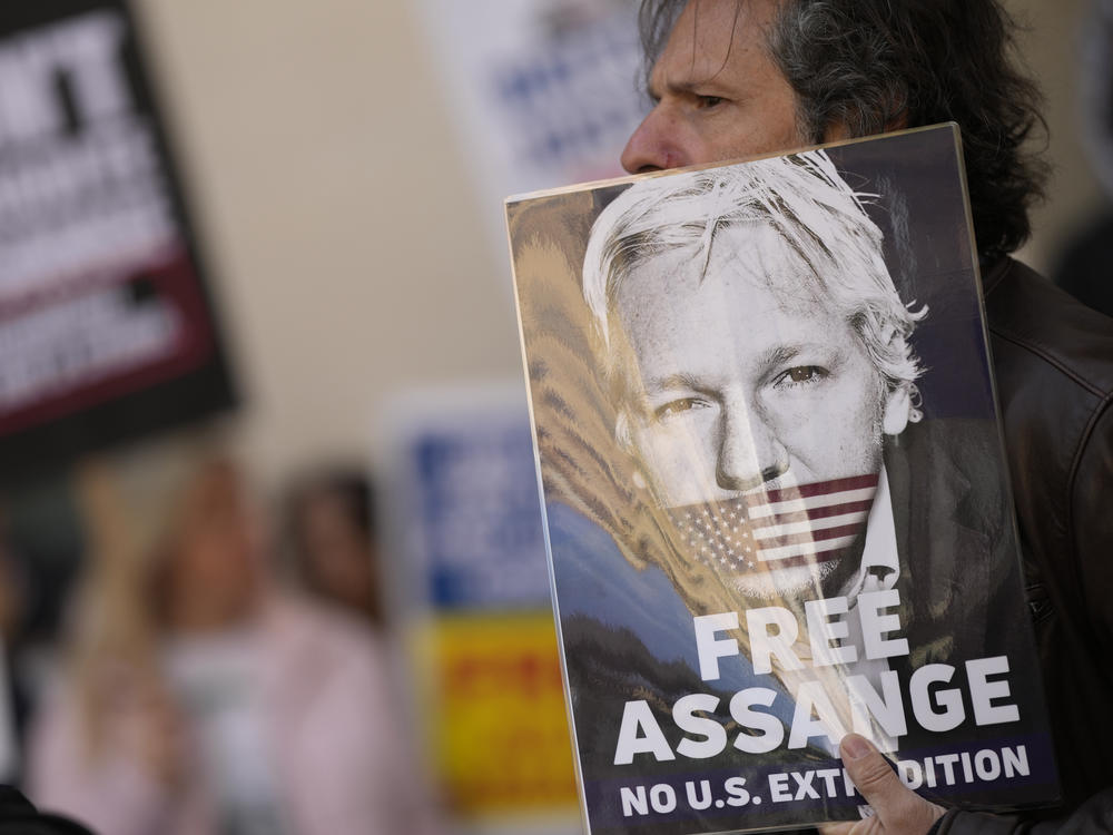 Wikileaks founder Julian Assange supporters hold placards as they gather outside Westminster Magistrates court in London on Wednesday.
