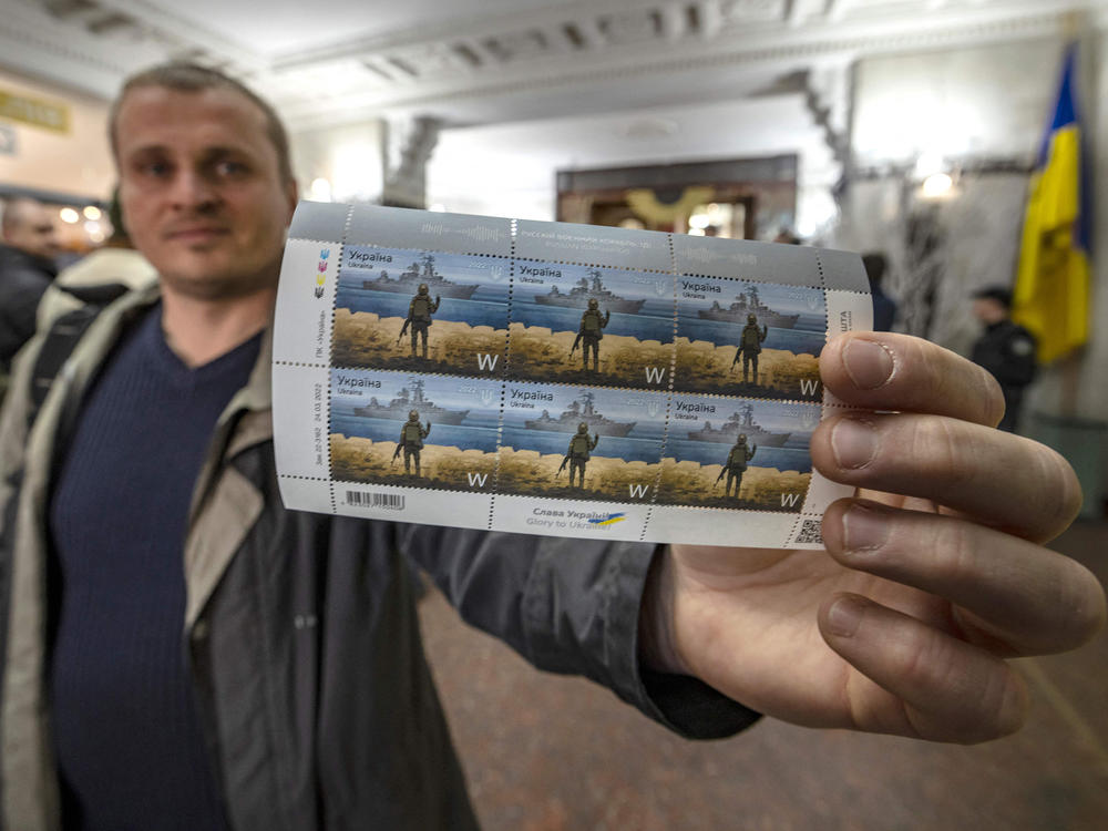A local resident shows new Ukrainian stamps titled 
