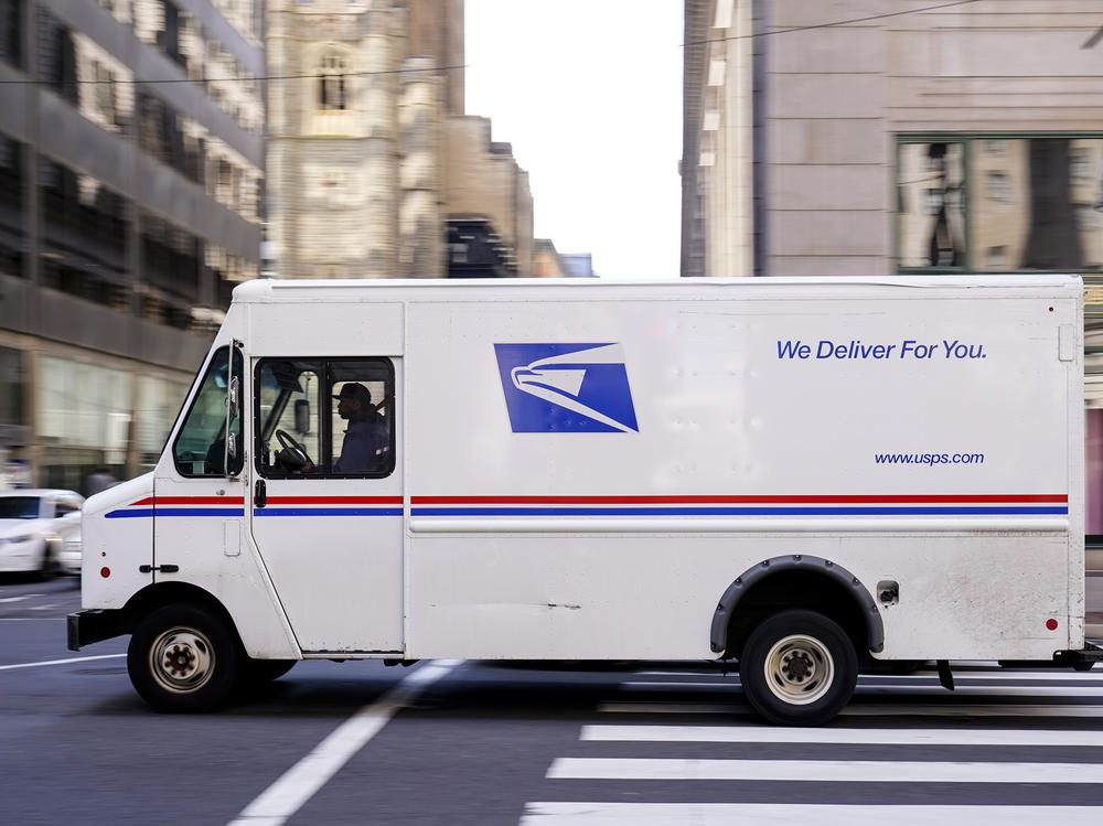 A U.S. Postal Service truck drives in Philadelphia. The service is about to set longer delivery standards for first-class packages, in a move that its regulator says will not have a big effect on its finances.