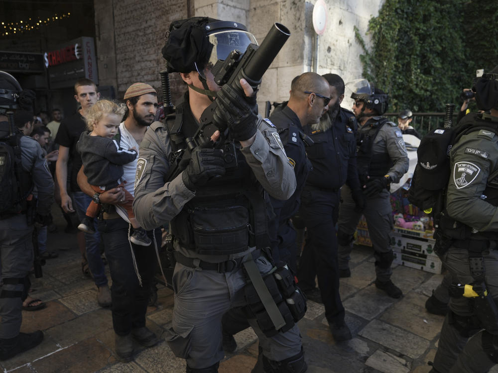 Israeli security forces escort a group of Jews outside Damascus Gate, in Jerusalem's Old City, Wednesday, April 20, 2022.